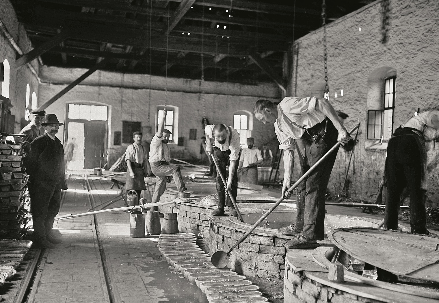 Historisches Foto von Hüttenarbeitern, die das gewonnene Metall weiterverarbeiten