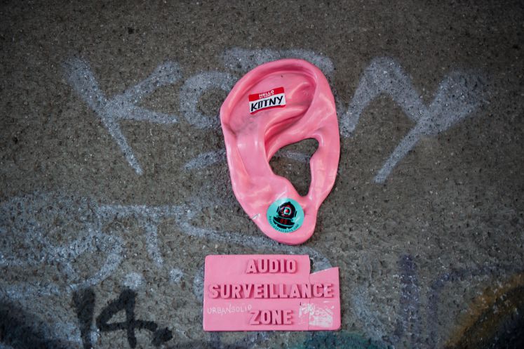 Ein überdimensionales Ohr mit einem Schild auf dem «Audio Surveillance Zone» (Abhörzone) zu lesen ist, hängt an einer Mauer am Alexanderplatz in Berlin