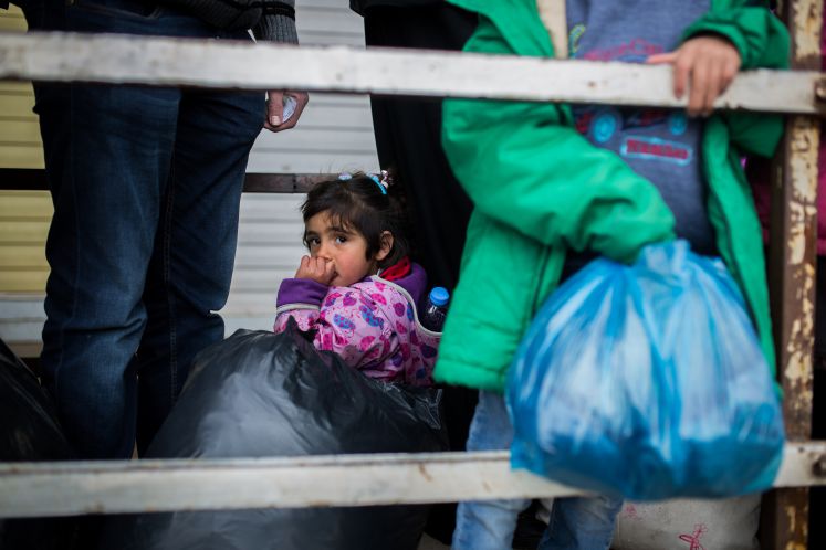 Ein Mädchen sitzt auf dem Boden und wartet auf die Aufnahme in ein Flüchtlingslager der südtürkischen Stadt Kilis