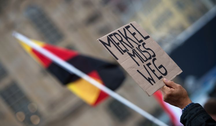 Plakat von Pegida Demonstranten am Tag der Deutschen Einheit mit dem Schriftzug "Merkel muss weg"