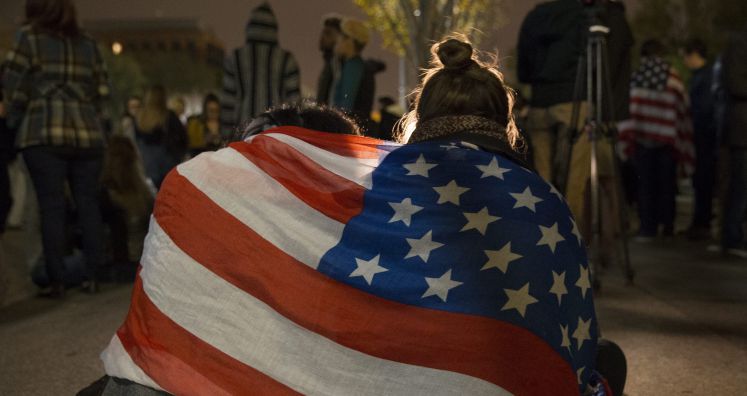 Weinende Clinton-Anhänger in eine US-Flagge gehüllt
