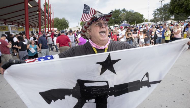 Ein Trump-Anhänger hält eine Fahne mit einem Maschinengewehr darauf