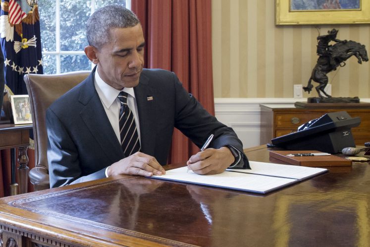 Barack Obama unterzeichnet im Oval Office ein Dekret.