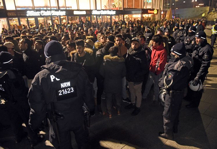 Polizisten umringen am 31.12.2016 vor dem Hauptbahnhof in Köln (Nordrhein-Westfalen) eine Gruppe südländisch aussehender Männer
