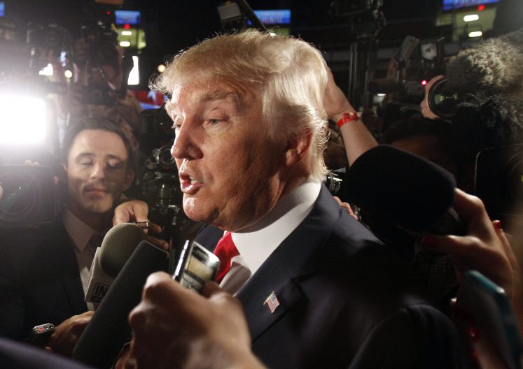 Donald Trump umzingelt von Mikrofonen und Kameras