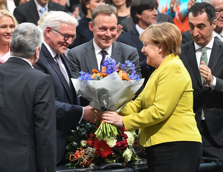 Bundeskanzlerin Angela Merkel überreicht dem frisch gewählten Bundespräsidenten Frank-Walter Steinmeier einen Blumenstrauß im Bundestag.