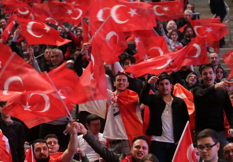 Eine Halle voller Deutschtürkei schwingt die türkische Flagge, während sie dem türkischen Ministerpräsidenten Yildirim zuhören.