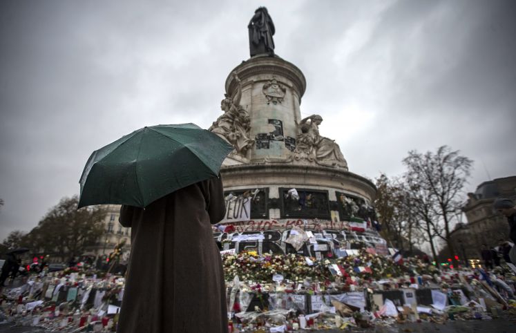 Eine Person, einen Regenschirm haltend, steht nach dem Terroranschlag vor dem Place de la Republique in Paris