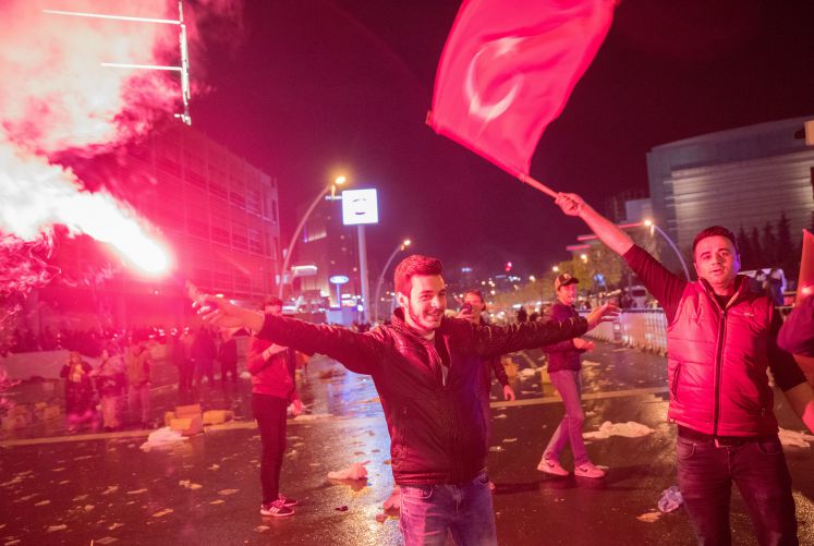 Jubelnde Türken stehen mit Bengalos am 16.04.2017 vor dem Hauptquartier der AKP in Ankara (Türkei) und feiern eine Zustimmung für das Verfassungsreferendum