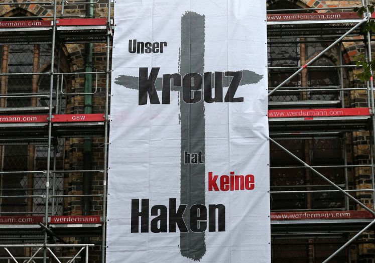 Ein Plakat zeigt die Aufschrift "Unser Kreuz hat keine Haken"