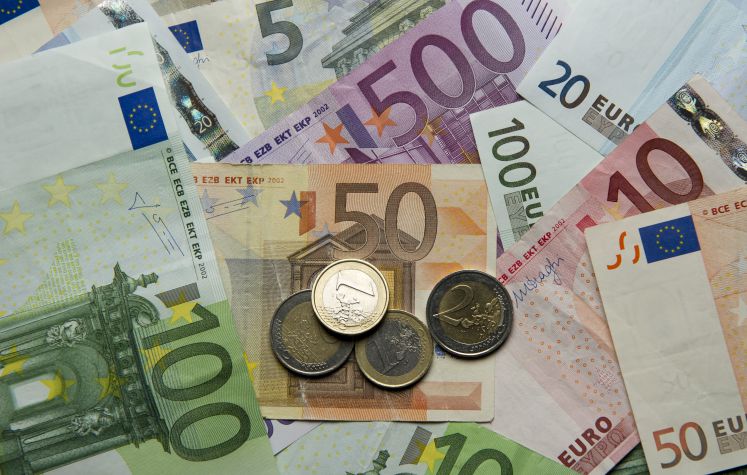 Zahlreiche Euro-Banknoten und Euromünzen
