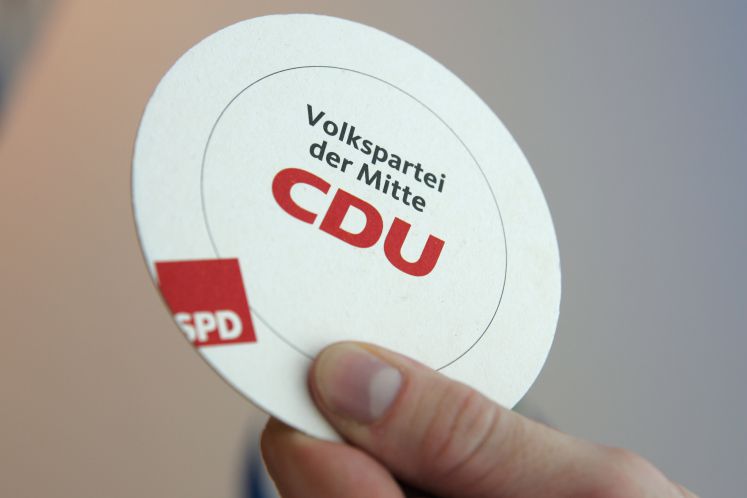Getränk-Untersetzer, auf dem in der Mitte "Volkspartei der Mitte - CDU" und am Rand "SPD" steht