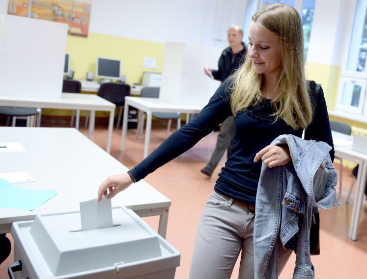 17-jährige Erstwählerin wirft ihren Wahlzettel in eine Urne