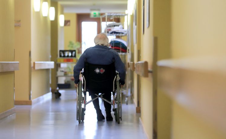 Ein Mann fährt im Rollstuhl über den Gang eines AWO-Seniorenzentrums