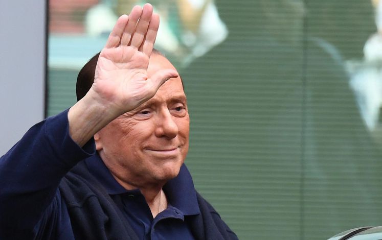 Silvio Berlusconi winkt jemandem zu.