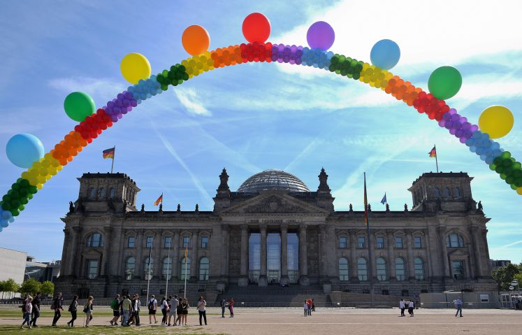Aktivisten halten vor dem Bundestag einen Regenbogen aus Luftballons in die Höhe