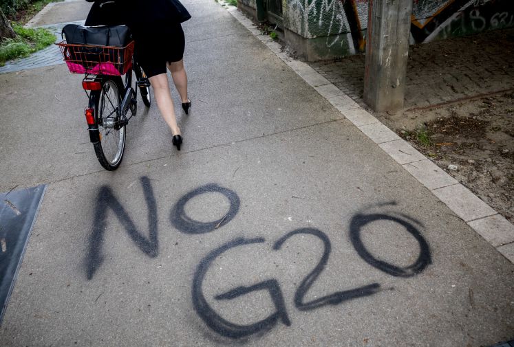 Auf den Gehweg ist mit schwarzer Farbe "No G20" gesprüht.