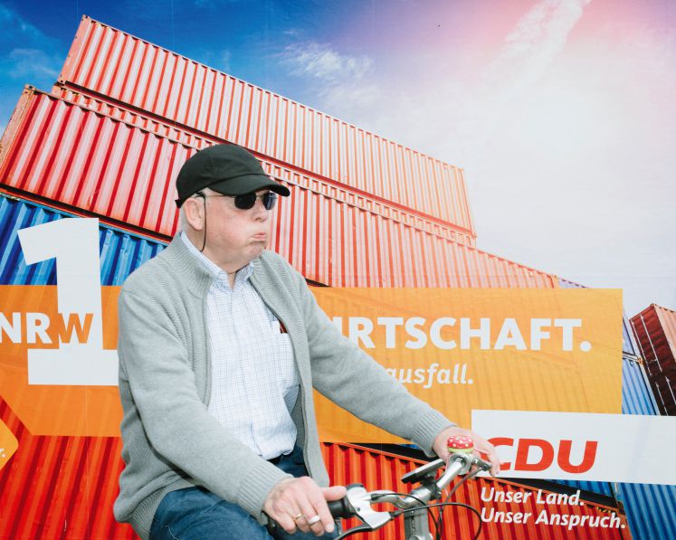 Ein Mann auf dem Fahrrad vor einem CDU Wahlplakat.