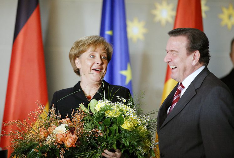 Machtwechsel 2005: Angela Merkel und Gerhard Schröder mit Blumen.