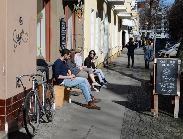 Gäste sitzen vor dem Café Gordon in Berlin, Neukölln im  April 2016.