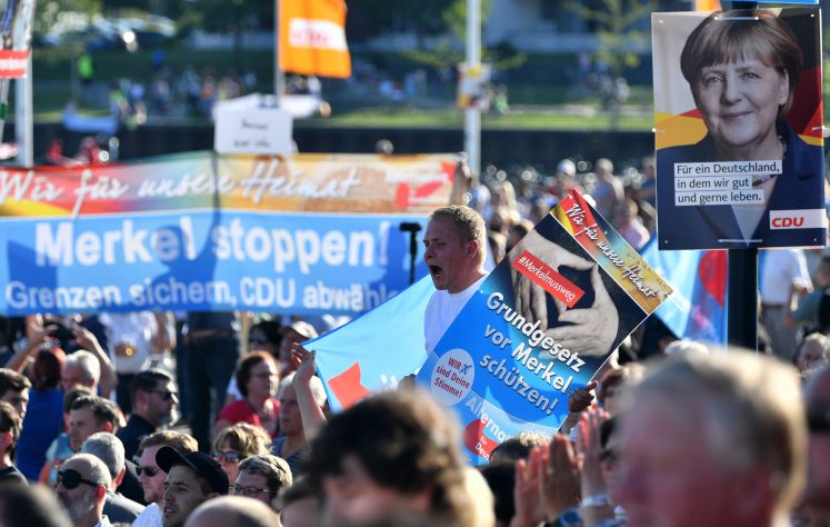 Mitglieder und Sympathisanten der AfD protestieren am 29.08.2017 während eines Wahlkampfauftritts von Bundeskanzlerin Angela Merkel in Bitterfeld-Wolfen (Sachsen-Anhalt).
