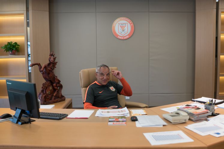 Felix Magath sitzt am Schreibtisch in seinem Büro des chinesischen Fußballclubs Shandong Luneng