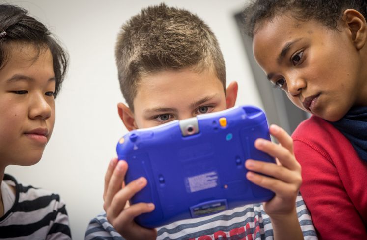 Schüler einer sechsten Klasse begutachten das Lernspiel "Teenage Mutant Ninja Turtles" auf einem "Storio"-Tablet.