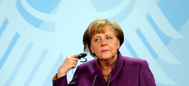 Bundeskanzlerin Angela Merkel nimmt bei einer Pressekonferenz einen Kopfhörer aus dem Ohr 