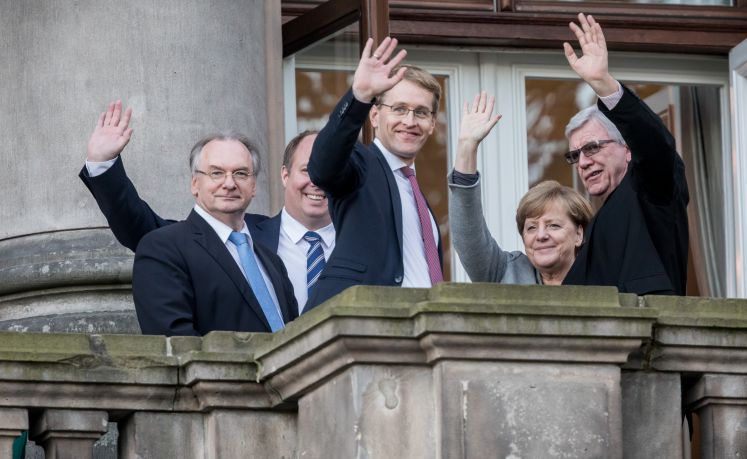 Merkel und andere an den Sondierungsgesprächen beteiligte Politiker winken vom Balkon der Parlamentarischen Gesellschaft