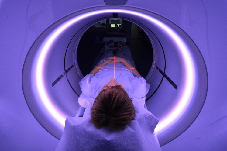 In der Zentralen Notaufnahme des Universitätsklinikums Jena (UKJ) liegt eine Röntgenassistentin am 20.01.2016 in Jena (Thüringen) zum Zwecke der Demonstration des Geräts in einem Computertomographe