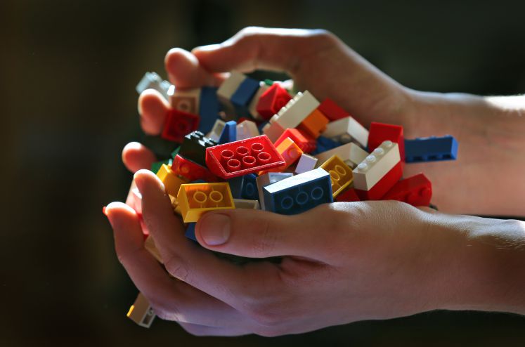 Zwei Hände mit Lego-Steinen