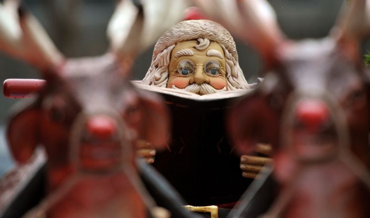 Eine lesender Weihnachtsmann sitzt in seinem Rentierschlitten, aufgenommen am Donnerstag (22.12.2011) auf dem Weihnachtsmakrt in Leipzig. 