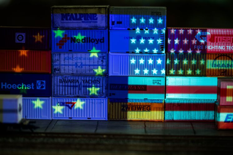Die Flaggen von Europa und den USA werden in Schwerin (Mecklenburg-Vorpommern) mit einem Beamer auf Container einer Modellba6 in Schwerin (Mecklenburg-Vorpommern) mit einem Beamer auf Container einer Modellbahn-Anlage projiziert