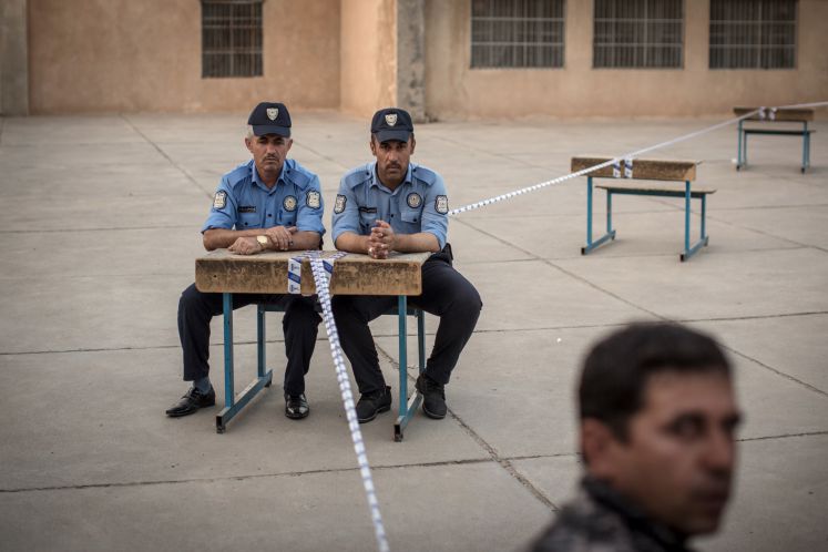 Polizisten sitzen am 25.09.2017 in Erbil (Irak) vor einem Wahllokal.