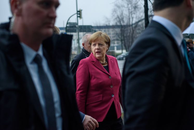 Angela Merkel umgeben von Sicherheitsleuten