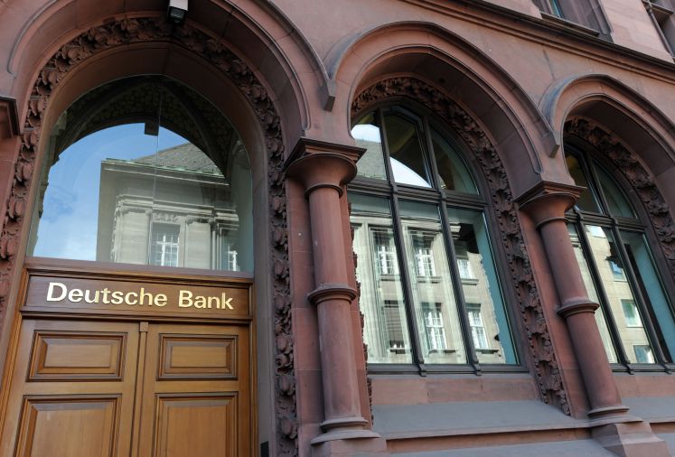 Die Zentrale der Privatbank Sal. Oppenheim spiegelt sich in den Fenstern einer Filiale der Deutschen Bank am Donnerstag in Köln