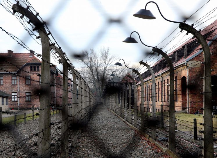 Blick durch Stacheldraht in das frühere Vernichtungslager Auschwitz-Birkenau