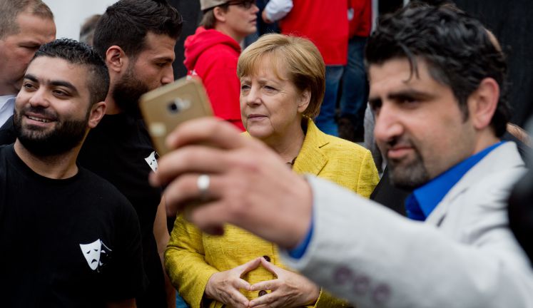 Syrische Flüchtlinge machen ein Selfie mit Bundeskanzlerin Angela Merkel