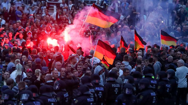 Demonstranten der rechten Szene zünden Pyrotechnik und schwenken Deutschlandfahnen. Nach einem Streit war in der Nacht zu Sonntag in der Innenstadt von Chemnitz ein 35-jähriger Mann erstochen worden.