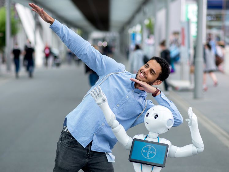 Jerome ist während der Digitalisierungsmesse Cebit mit dem Roboter Bobby von Aussteller Bayer auf dem Messegelände unterwegs.