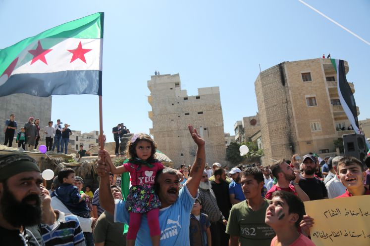 Demonstranten protestieren mit einer Flagge der Opposition gegen die erwartete Militäroffensive der syrischen Armee auf die Rebellenhochburg in der Provinz Idlib. 