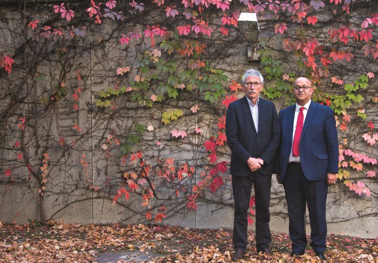 Thilo Sarrazin und Abdel-Hakim Ourghi stehen vor einer Wand im Herbstlaub