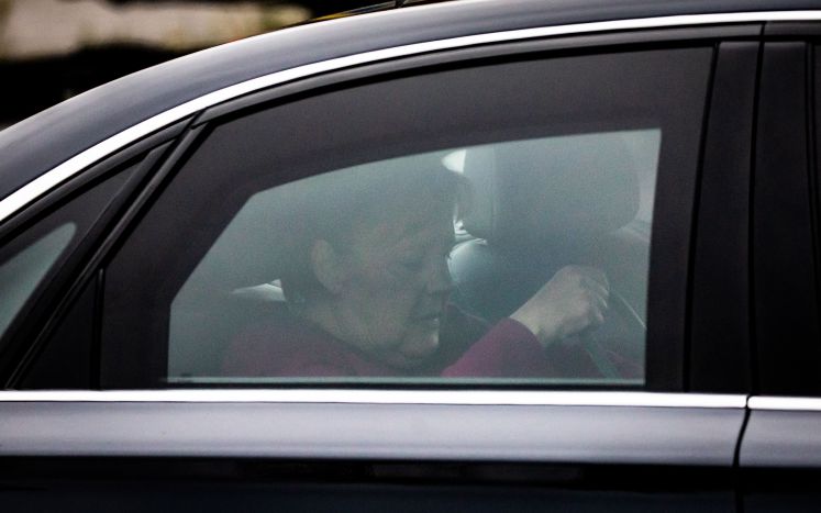 Angela Merkel hinter dem Fenster eines Autos