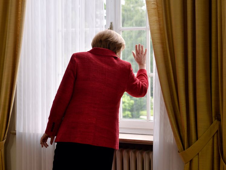 Angela Merkel steht an einem Fenster