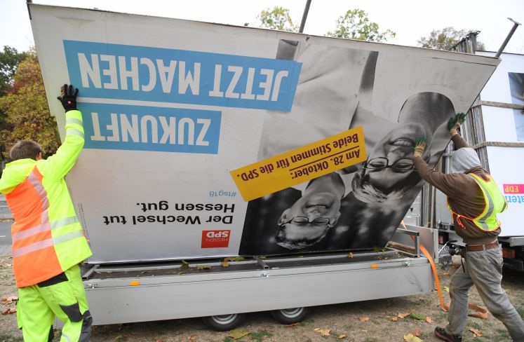 Arbeiter verladen ein Wahlplakat für den SPD-Spitzenkandidaten Thorsten Schäfer-Gümbel auf einen Anhänger. 
