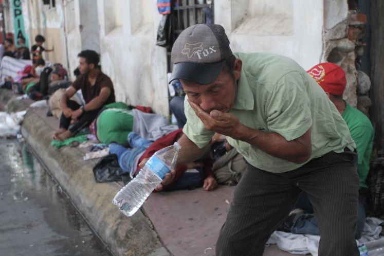 23.10.2018, Mexiko, Huixtla: Ein Migrant aus Mittelamerika trinkt Wasser aus einer Plastikflasche in der Nähe des Hauptplatzes der Stadt Huixtla. Auf ihrem Weg Richtung US-Grenze haben Tausende Migranten aus Mittelamerika einen Stopp in der südmexikanischen Stadt Huixtla eingelegt. 
