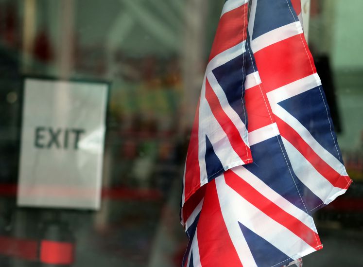 Die Flaggen Großbritanniens und Nordirlands vor einem Exit-Schild in London