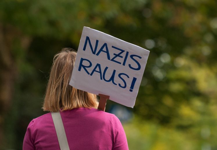 Eine Demonstrantin protestiert mit dem Schild «Nazis raus!»