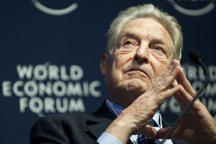 George Soros am Mikrofon mit gefalteten Händen während des World Economic Forum