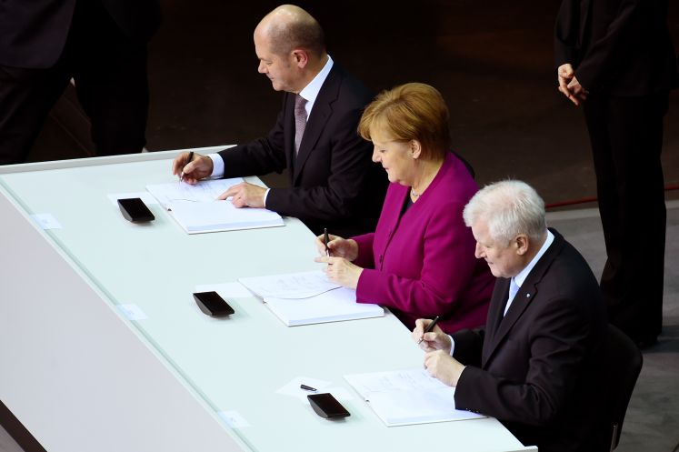 Bundeskanzlerin Angela Merkel (CDU), der CSU-Vorsitzende Horst Seehofer (r) und der kommissarische SPD-Vorsitzende Olaf Scholz unterzeichnen im Paul-Löbe-Haus den Koalitionsvertrag. 